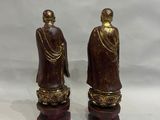 pair of asian figurines of a monk and a buddhist monk
