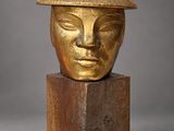 an image of a gold colored sculpture of a woman ' s face