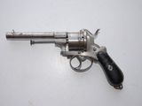 an old silver revolver with a black handle on a white surface