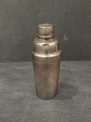 a small metal shaker sitting on a table