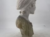 a white marble bust of a woman with a turban on her head