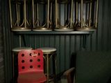 une chaise rouge posée devant une pile de chaises