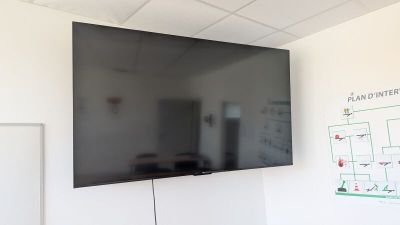 un téléviseur à écran plat fixé au mur d'une pièce