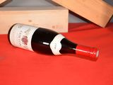 a bottle of wine sitting on a table next to a wooden box