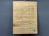 an old piece of paper hanging from a hook on a wall