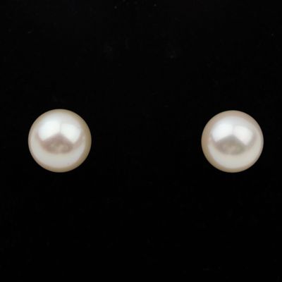 une paire de boucles d'oreilles en perles blanches sur fond noir