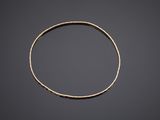 a close up of a gold bracelet on a black background