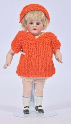a doll that is wearing an orange dress and hat