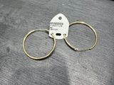 une paire de boucles d'oreilles créoles en or posée sur une table