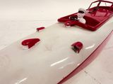 a red and white boat on a white surface