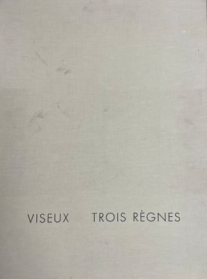 un vieux livre posé sur une table en bois à côté d'une fenêtre