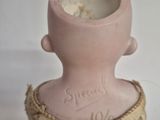 a small pink vase with writing on it sitting on a table