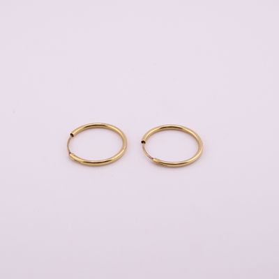 une paire de boucles d'oreilles en or sur fond blanc