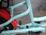 a blue bicycle with a red seat and a black handlebar