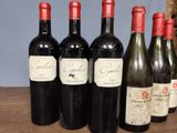 several bottles of wine are lined up on a wooden table