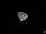 a diamond on a black surface with a black background