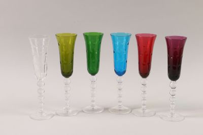 four different colored wine glasses are lined up in a row