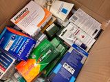 a cardboard box filled with toothpaste, toothpaste, and other hygiene products