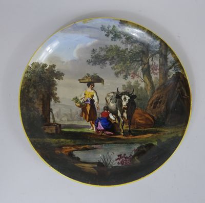 une assiette sur laquelle est représentée une femme et deux vaches