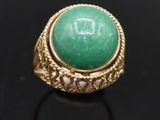 Gros plan sur une bague contenant une pierre verte