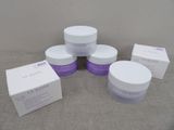 quatre pots de produits de soin posés sur une table