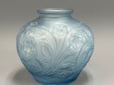 un vase en verre bleu orné d'un motif floral