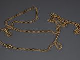 a close up of a gold chain with a clasp on a gray background