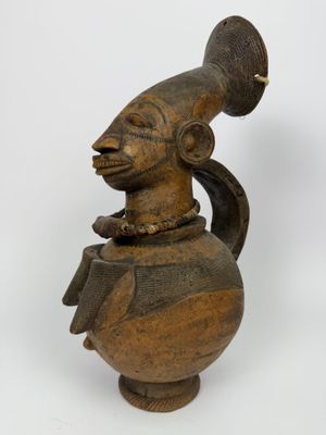 une image représentant une statue en bois d'un homme portant un chapeau sur la tête
