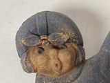 an old wooden doll with a hat on it ' s head