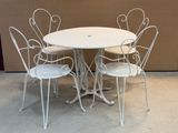 une table blanche entourée de quatre chaises dans une pièce