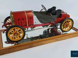 a small model of a car on display on a wooden stand