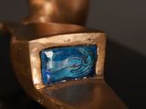 a gold statue with a blue glass in the middle of it