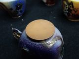 a blue vase with a brown lid sitting on a table