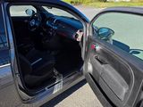 a silver car with its door open on the street
