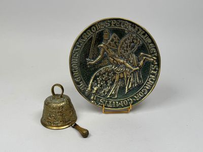 une vieille cloche et une médaille sur un fond blanc