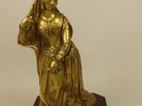brass figurine of a woman holding a basket of flowers on a wooden base