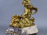 a gold statue of a child and a dog on a marble base