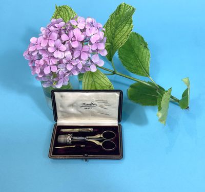 a small box with a pair of scissors in it