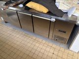 une photo d'une cuisine avec tout un tas d'objets posés sur le plan de travail