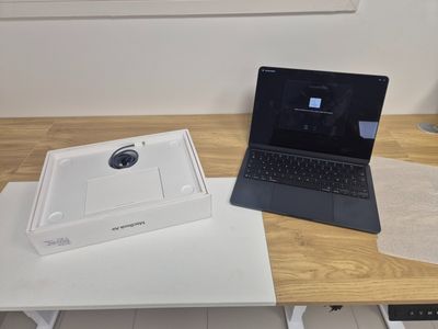 a laptop computer sitting on top of a table next to a laptop computer