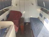 two beds in the back of a boat with a red and blue cover