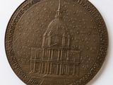 a bronze medal with a picture of a building on it