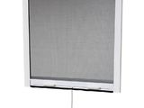 a close up of a window with a white roller shade on it