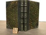 an old book with two books on top of it on a table