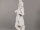 a white statue of a man with a bird on his head