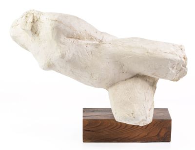 une sculpture représentant une personne allongée sur un socle en bois