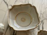 a white bowl with a gold rim sitting on a marble table