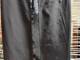 a black skirt hanging on a rack in a room