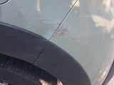 a cat that is laying under the tire of a car