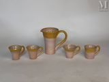 cinq tasses et un pichet posés sur une table